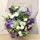 Bouquet violet avec des roses banches des giroflées du gypsophile du lisianthus et du feuillages 