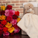 Multicoloured roses and cuddly teddy bear