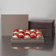 Rote Schachtel mit Schokoladenherzen und ein Rosenstrauß